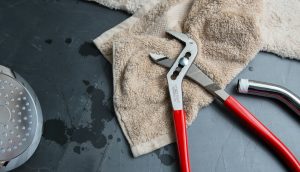 technician performing plumbing repair services to prevent water damage