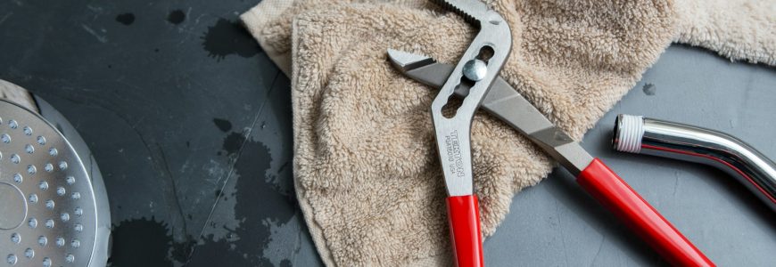 technician performing plumbing repair services to prevent water damage