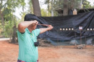 man participating in outdoor slingshot activity representing community sports engagement