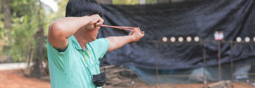 man participating in outdoor slingshot activity representing community sports engagement